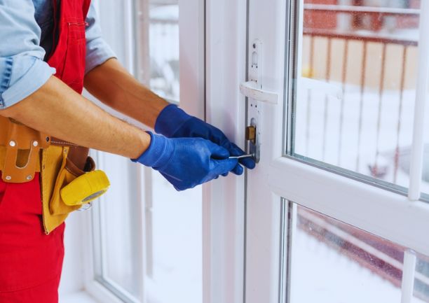 A worker in gloves checks the door lock
